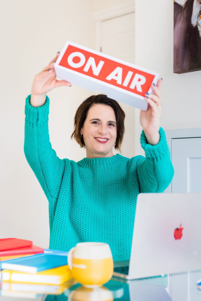 Alison Ellerbrook with On Air Sign